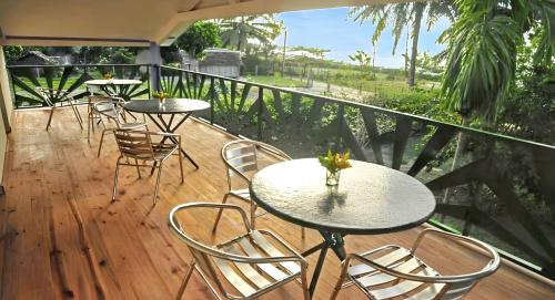 a patio with tables and chairs on a deck at Charming Villa in Foulpointe with Sea View in Foulpointe