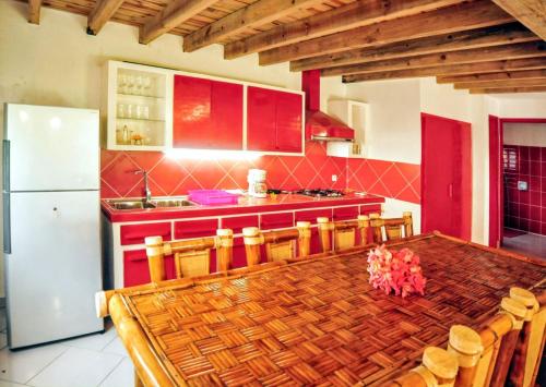 a kitchen with a table and a refrigerator at Charming Villa in Foulpointe with Sea View in Foulpointe