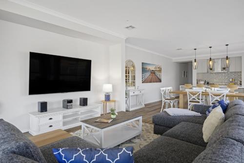 a living room with a couch and a tv at Summerhouse 5min walk to the beach 7min drive to Hot Springs in Capel Sound