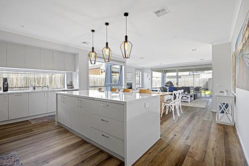 an open kitchen and dining room with white cabinets at Summerhouse 5min walk to the beach 7min drive to Hot Springs in Capel Sound
