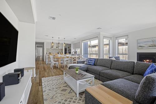 a living room with a couch and a table at Summerhouse 5min walk to the beach 7min drive to Hot Springs in Capel Sound