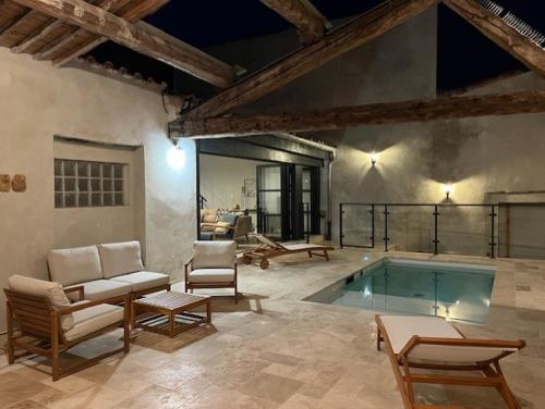 Cette chambre dispose d'une piscine avec des chaises et une table. dans l'établissement Hidden Oasis - Maison de caractère avec piscine, à Azille