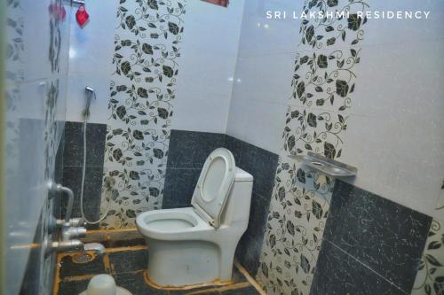 a bathroom with a toilet and a shower curtain at Sri Lakshmi Residency in Tirupati