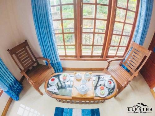a room with a table and two chairs and a window at Ulpatha Guest House in Hatton