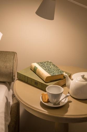a table with a tea pot and a book at B&B Antico Brolo in Gardone Riviera