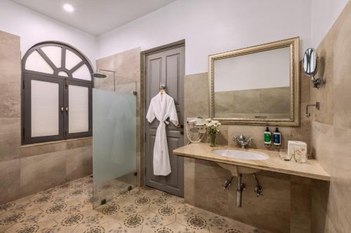 a bathroom with a sink and a mirror and a shower at The Source At Sula in Nashik