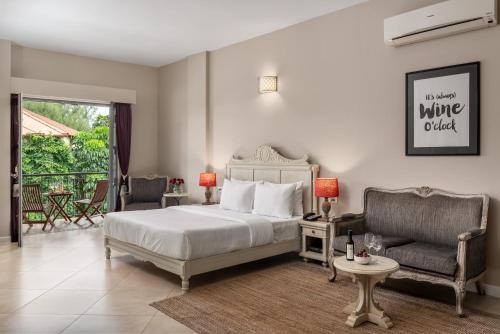 a bedroom with a bed and a couch and a chair at The Source At Sula in Nashik