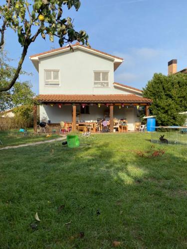 a house with a porch and a yard with green grass at Casita Azul Homestay in Cáseda