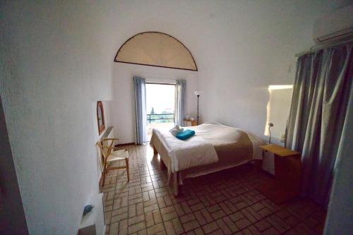 ein Schlafzimmer mit einem Bett und einem Fenster in der Unterkunft Villa Orea Elena-Mani-Kalamata in Verga Kalamata