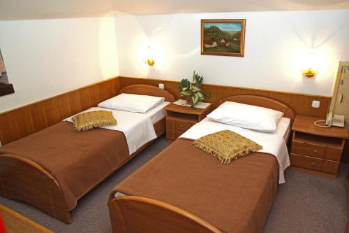 a hotel room with two beds in a room at Guest house Royal in Čakovec