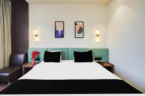 a hotel room with a large bed and a chair at Townhouse Arvind Marg Pachamarhi in Pachmarhī