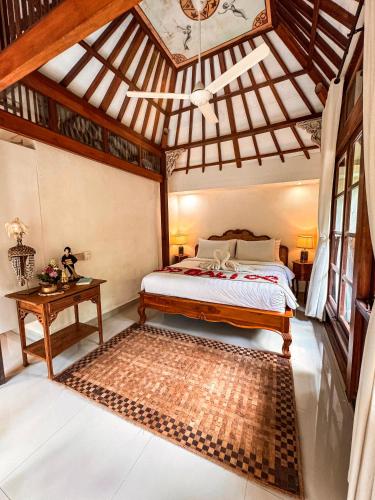 a bedroom with a bed and a wooden ceiling at Bali Maison in Ubud