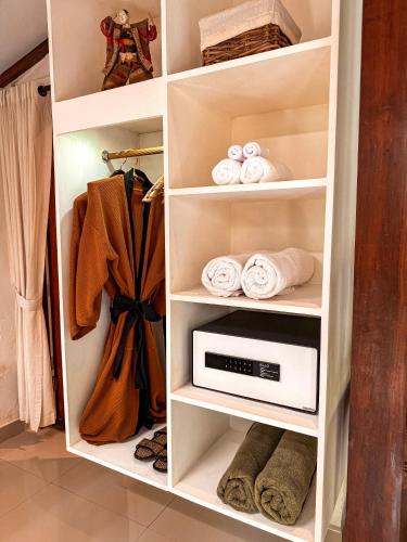 a closet with a white cabinet with a microwave at Bali Maison in Ubud