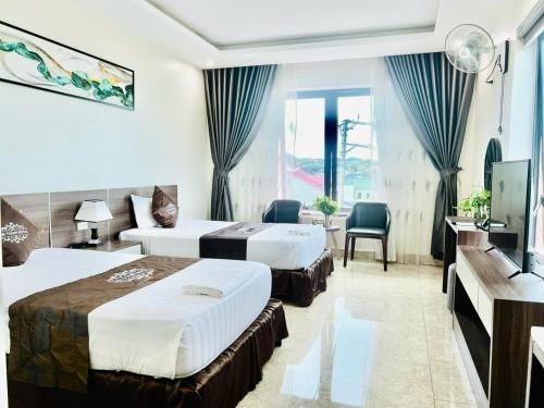 a hotel room with two beds and a television at Khách Sạn Đại Thành in Anh Sơn
