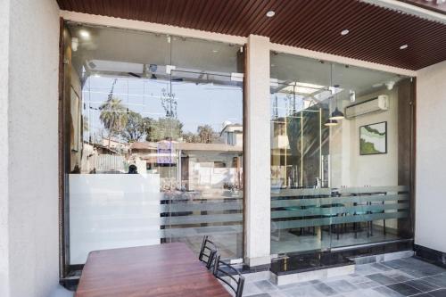 a large window of a store with a wooden table at Townhouse Arvind Marg Pachamarhi in Pachmarhī