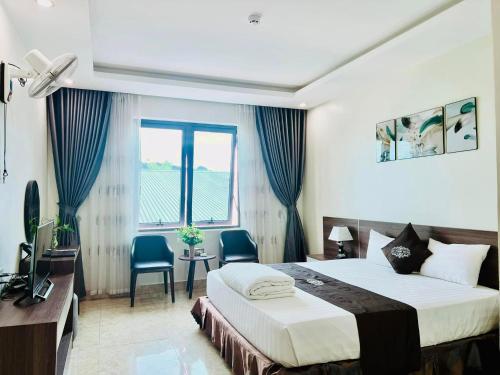 a hotel room with a bed and a desk and a window at Khách Sạn Đại Thành in Anh Sơn