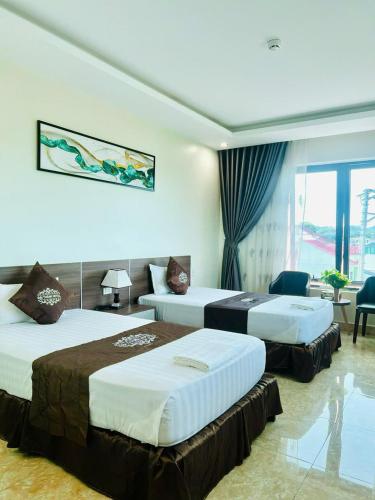 a hotel room with three beds in a room at Khách Sạn Đại Thành in Anh Sơn
