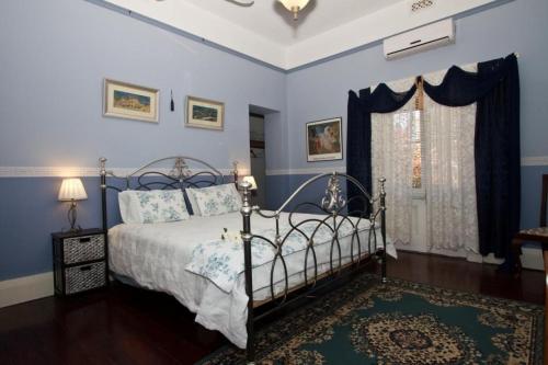 a bedroom with a bed with blue walls at Weelaway On Gregory in Geraldton