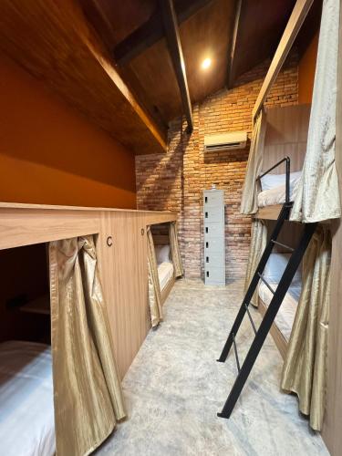 a room with two bunk beds and a brick wall at Hotel Ban Sheng Teik in Ipoh