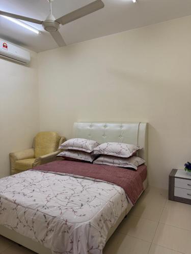 a bedroom with a bed and a chair at Adawiyah Guest House, Gambang in Gambang