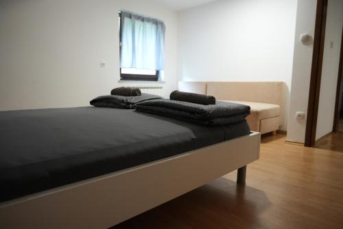 a bed with pillows on top of it in a room at Rooms and apartments Biš in Trnovska Vas