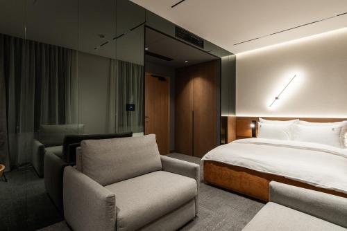 a hotel room with a bed and a chair at Garni Hotel Galeria in Banja Luka