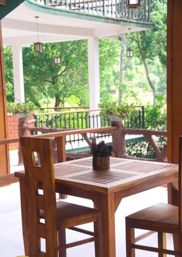 a wooden table and chairs on a porch at Rawana Mount View - Ella in Bandarawela