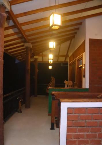 a living room with a wooden ceiling and a table at Rawana Mount View - Ella in Bandarawela