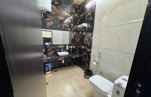 a bathroom with a sink and a toilet and a mirror at Mahua Monks in Udaipur