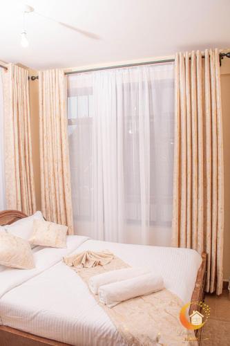a bed in a room with a large window at Dreamy Deluxe Furnished Apartment in Nakuru