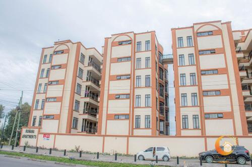 a large building with cars parked in front of it at Dreamy Deluxe Furnished Apartment in Nakuru