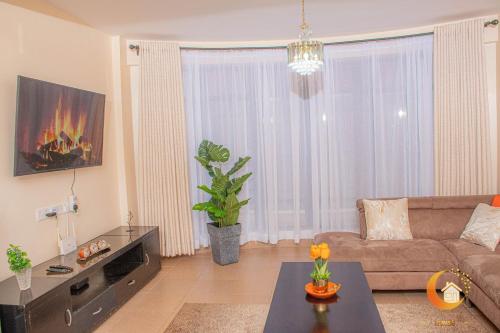 a living room with a couch and a table at Dreamy Deluxe Furnished Apartment in Nakuru
