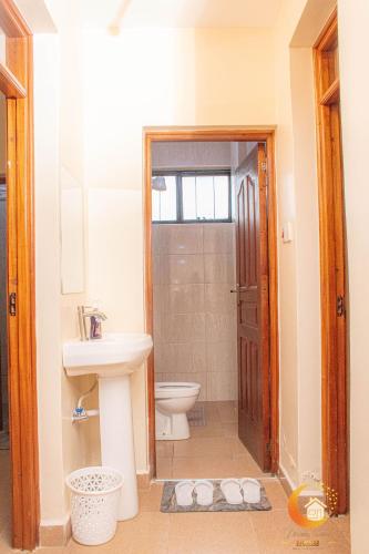 a bathroom with a toilet and a sink at Dreamy Deluxe Furnished Apartment in Nakuru