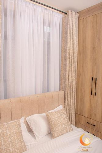 a bedroom with a bed with a large window at Dreamy Deluxe Furnished Apartment in Nakuru