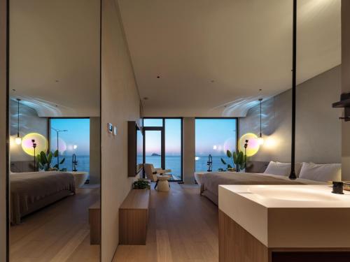a bathroom with two beds and a sink in a room at Qingdao Wushe Yujianshanju Tangchi Seaview Hotel in Qingdao