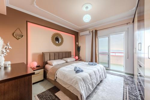 a bedroom with a bed and a large window at Aria Apartment in Durrës