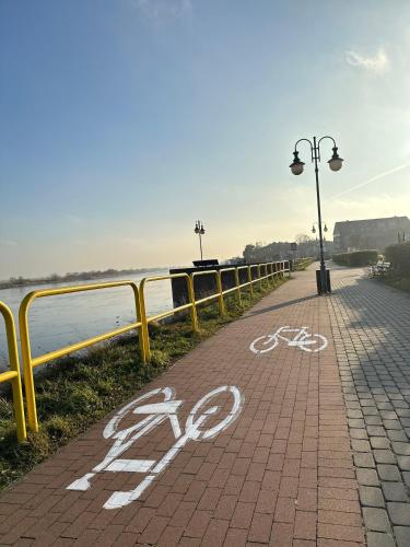 a bike lane on a sidewalk next to the water at Apartament Premium Zamkowa B21 in Tczew