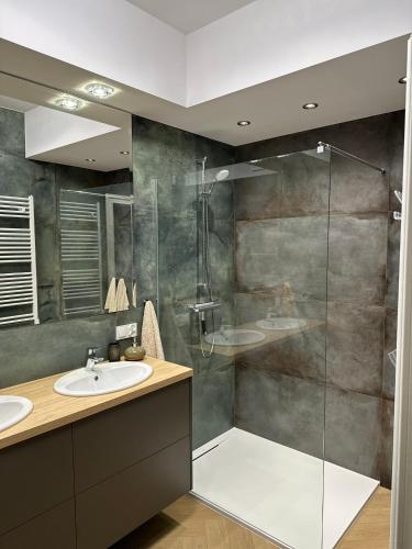 a bathroom with a glass shower and a sink at Apartament Premium Zamkowa B21 in Tczew