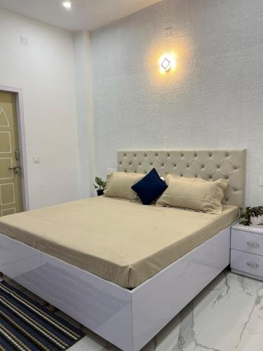 a bedroom with a large bed with a white headboard at 2nd Homes in Dehradun