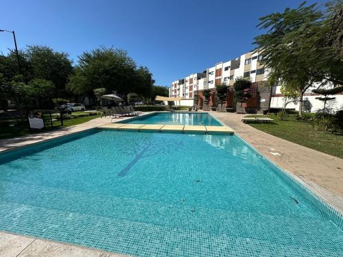 a large blue swimming pool with a building in the background at Departamento en Puerto Vallarta in Puerto Vallarta
