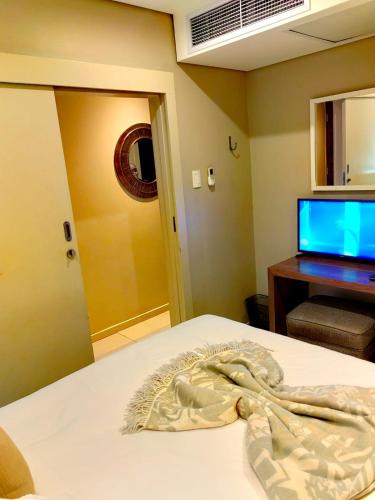 a bedroom with a bed with a television and a bed sidx sidx sidx at Zimbali Suite 417 in Ballito