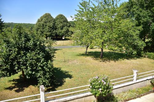 a fence in a field with trees and grass at Gîte La grave haute sud in Mauzac-et-Grand-Castang