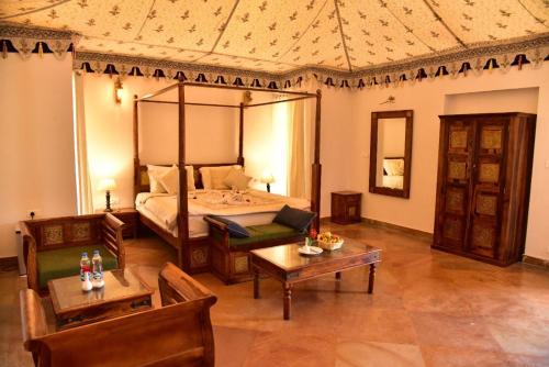 a bedroom with a bed and a couch and a table at Clarks Safari Ranthambore in Khilchipur