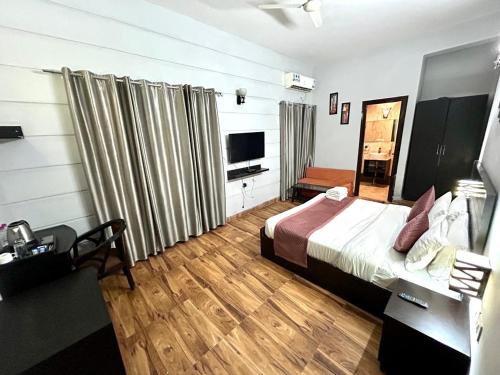 ChhatikaraDiamond palace的配有床和电视的酒店房间