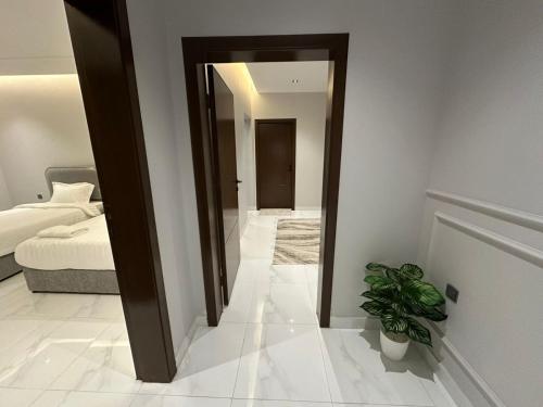 a bedroom with a mirror and a bed and a plant at شقة مفروشة بمنطقة هادئة in Makkah