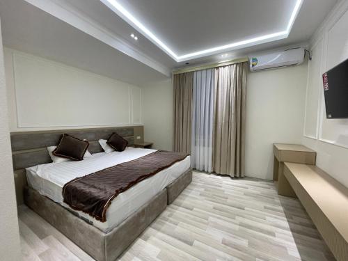 a hotel room with a bed and a television at Anor Qal'a in Khiva