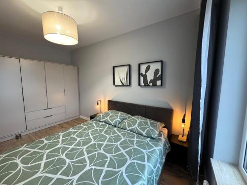 a bedroom with a bed and two pictures on the wall at Boho Escape & Parking in Częstochowa