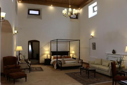 a living room with a bed and a couch and chairs at Swat Serena Hotel in Saidu