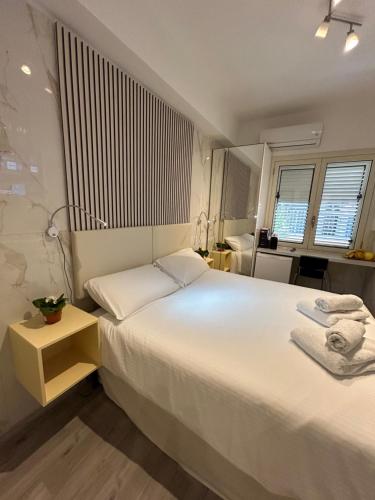 a bedroom with a large white bed and a window at Confort Suites in Reggio Calabria