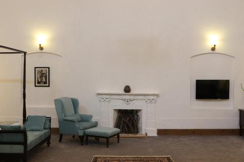 a living room with two chairs and a fireplace at Swat Serena Hotel in Saidu